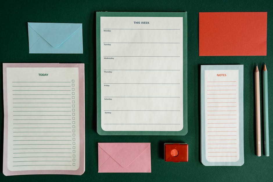 Flat lay of stationery items for planning and organization on a green background.